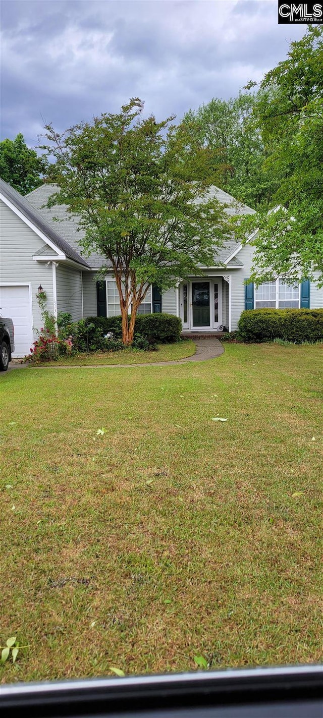 view of front of home with a front yard and a garage