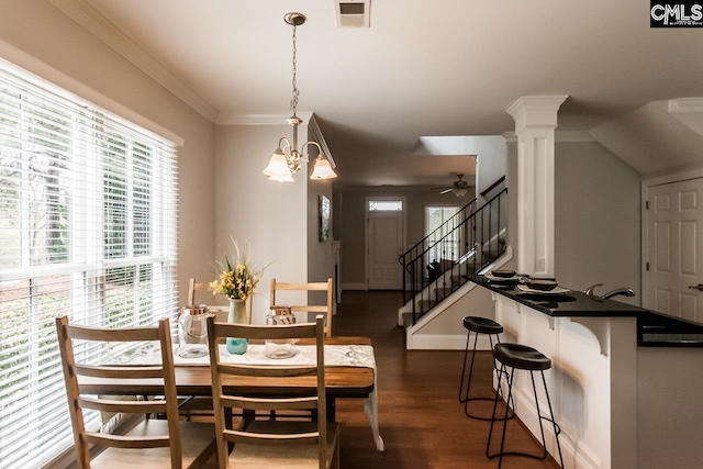 dining area with dark hardwood / wood-style floors, ornamental molding, ceiling fan with notable chandelier, and ornate columns