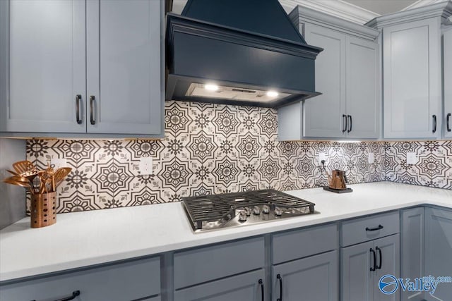 kitchen featuring stainless steel gas stovetop, decorative backsplash, and custom range hood