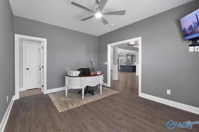 home office with ceiling fan and dark hardwood / wood-style flooring