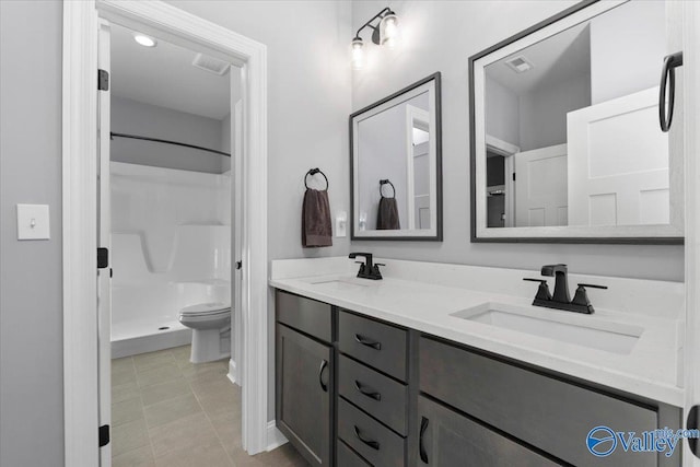 bathroom with tile patterned flooring, vanity, toilet, and a shower