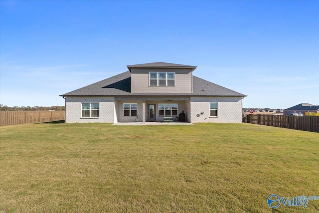 rear view of house featuring a yard and a patio