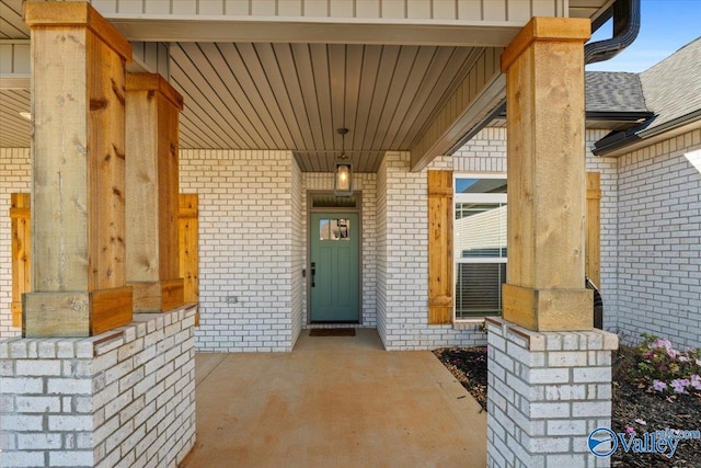 view of exterior entry featuring covered porch