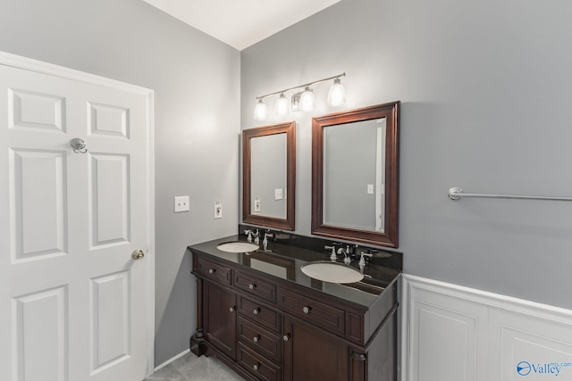 11228 Stewart Rd, Tanner, AL 35671 - bathroom featuring double vanity, a wainscoted wall, and a decorative wall