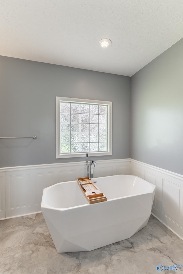 11228 Stewart Rd, Tanner, AL 35671 - full bathroom with a wainscoted wall, a decorative wall, and a freestanding tub