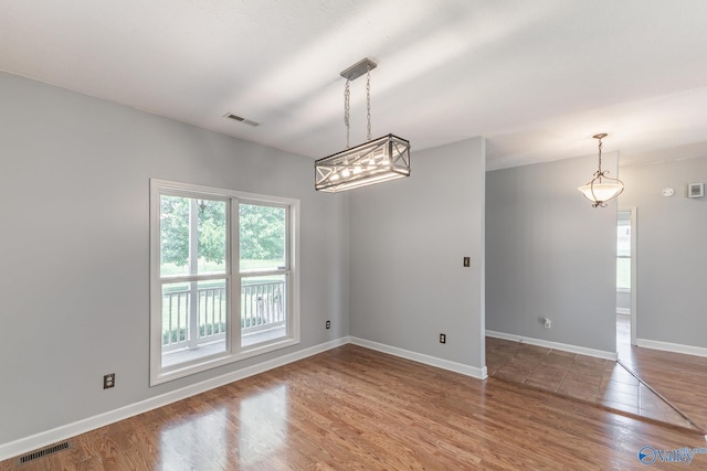 11228 Stewart Rd, Tanner, AL 35671 - spare room with wood finished floors, baseboards, and a chandelier