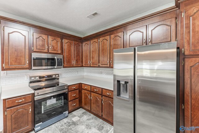 11228 Stewart Rd, Tanner, AL 35671 - kitchen with appliances with stainless steel finishes, light countertops, tasteful backsplash, a textured ceiling, and brown cabinetry
