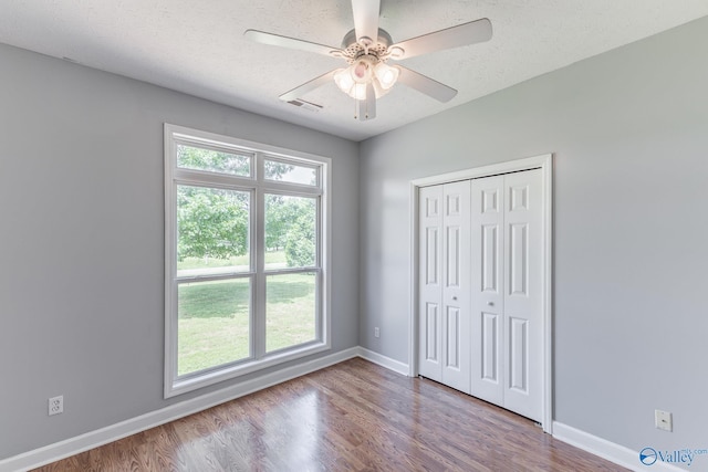 11228 Stewart Rd, Tanner, AL 35671 - unfurnished bedroom featuring baseboards, wood finished floors, a closet, and ceiling fan