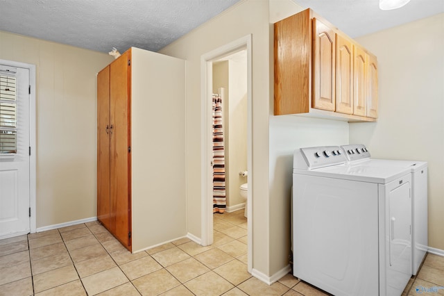 laundry area with independent washer and dryer and light tile patterned flooring