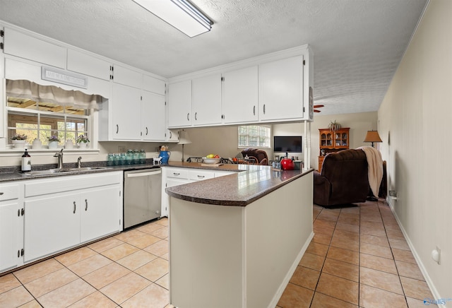 kitchen with open floor plan, dishwasher, a sink, and light tile patterned flooring