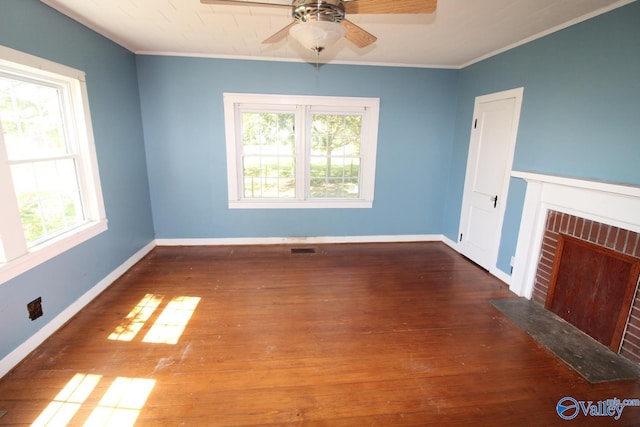 unfurnished living room with a fireplace, dark hardwood / wood-style flooring, a wealth of natural light, and ceiling fan