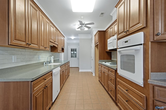 kitchen featuring light tile patterned floors, white appliances, backsplash, and a sink