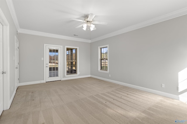 spare room with light carpet, ceiling fan, ornamental molding, and baseboards