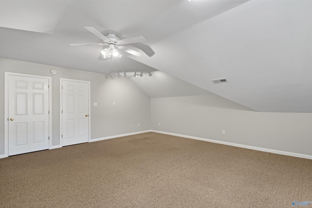 bonus room featuring lofted ceiling, ceiling fan, carpet floors, visible vents, and baseboards