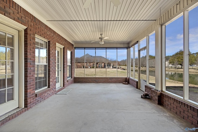 unfurnished sunroom featuring ceiling fan