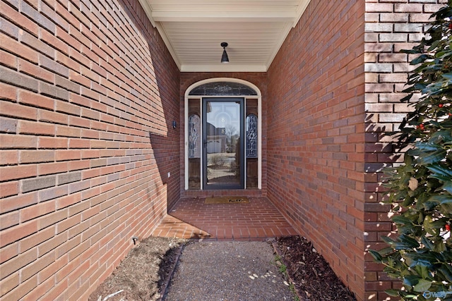 view of exterior entry featuring brick siding