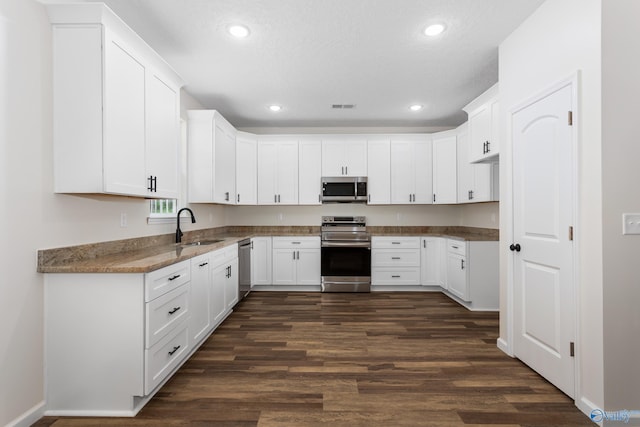 4452 Sibert St S, Gadsden, AL 35903 - kitchen featuring appliances with stainless steel finishes, dark wood finished floors, recessed lighting, white cabinetry, and stone countertops