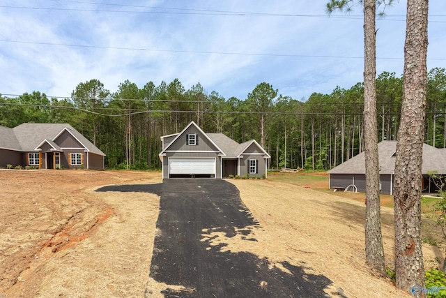 4452 Sibert St S, Gadsden, AL 35903 - view of front of house with an attached garage, asphalt driveway, and a wooded view