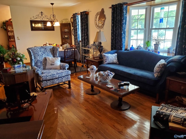 living room featuring wood-type flooring and a chandelier