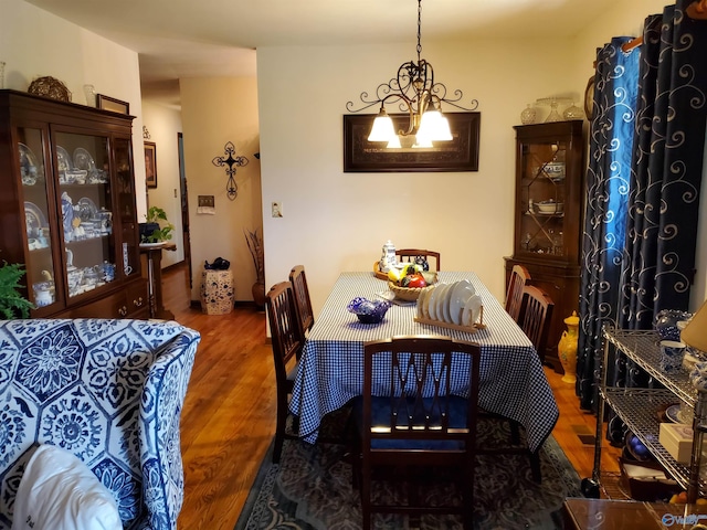 dining space with an inviting chandelier and dark hardwood / wood-style flooring