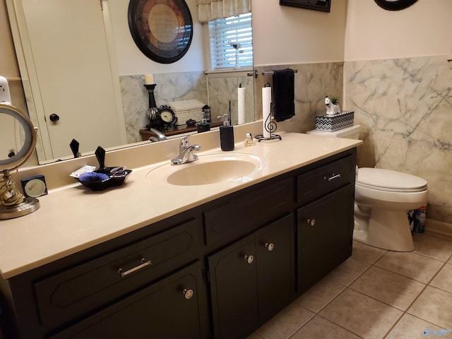 bathroom featuring tile patterned floors, toilet, vanity, and tile walls