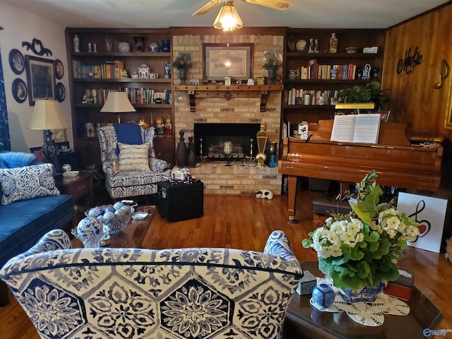 living room featuring wood-type flooring, a brick fireplace, and ceiling fan
