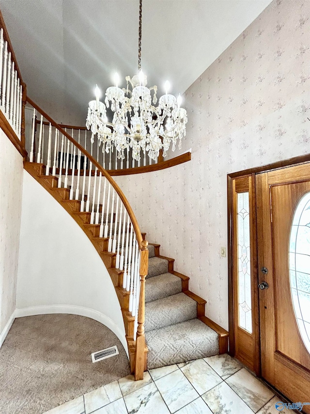 entryway featuring an inviting chandelier, light tile patterned floors, and vaulted ceiling