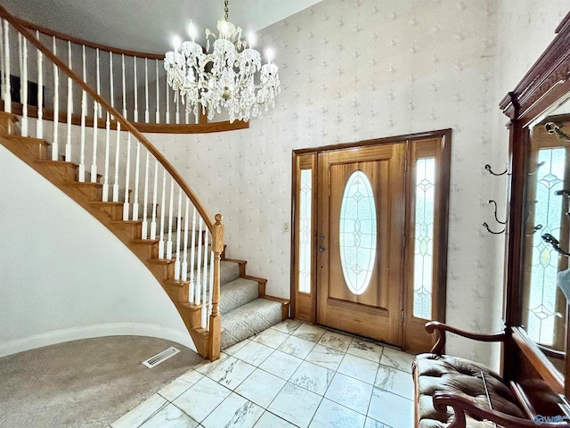 entrance foyer with light tile patterned flooring, a high ceiling, and a chandelier