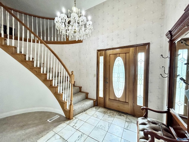 foyer entrance featuring a healthy amount of sunlight, visible vents, and wallpapered walls