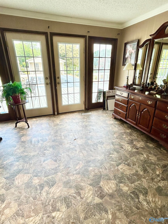 interior space featuring ornamental molding, tile patterned flooring, a healthy amount of sunlight, and a textured ceiling