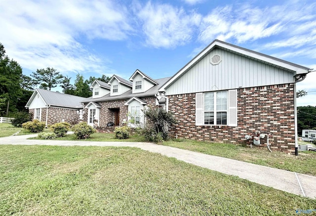 view of front of property with driveway, a front lawn, and brick siding