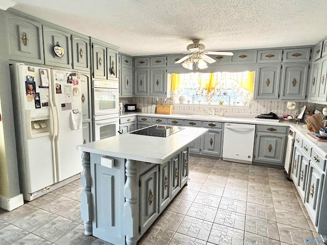 kitchen with tasteful backsplash, light tile patterned floors, white appliances, a kitchen island, and ceiling fan