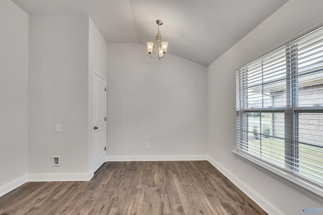 empty room featuring dark hardwood / wood-style floors, an inviting chandelier, plenty of natural light, and lofted ceiling