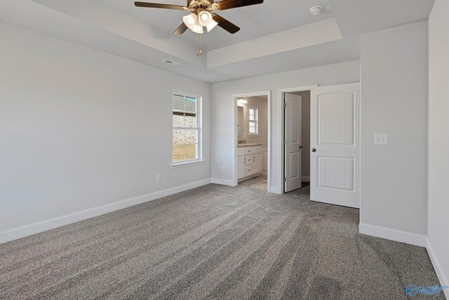 carpeted empty room featuring a tray ceiling and ceiling fan