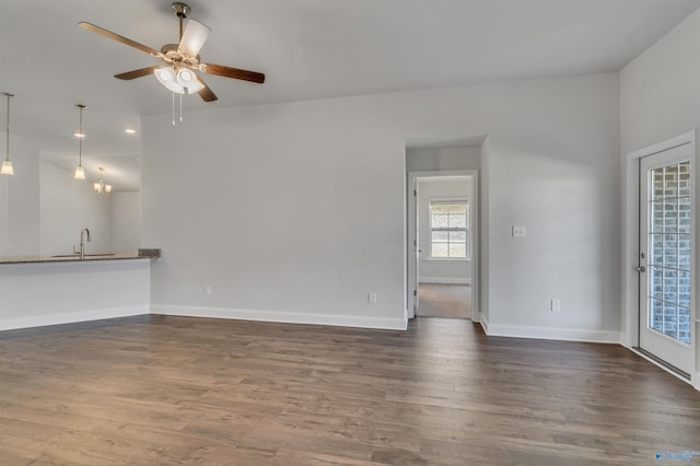 unfurnished living room with ceiling fan, dark wood-type flooring, and sink