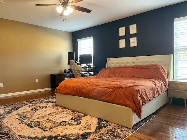 bedroom featuring a textured ceiling, dark hardwood / wood-style flooring, multiple windows, and ceiling fan