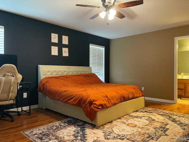 bedroom with connected bathroom, ceiling fan, sink, a textured ceiling, and hardwood / wood-style flooring