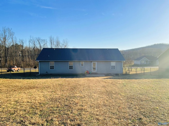 rear view of house featuring a yard