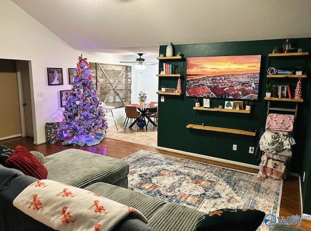 living room with ceiling fan, hardwood / wood-style floors, and lofted ceiling