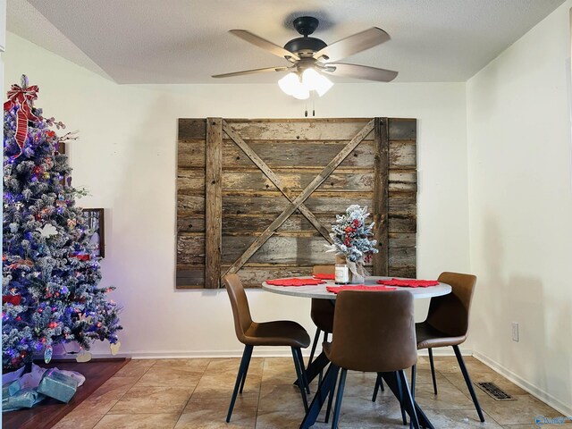 dining area with a textured ceiling, tile patterned floors, and ceiling fan