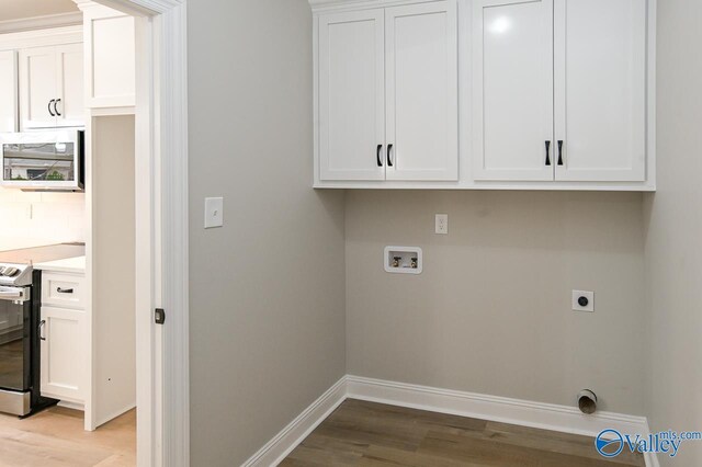 laundry area with electric dryer hookup, cabinets, hookup for a washing machine, and light hardwood / wood-style floors