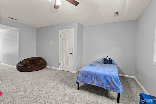 bedroom featuring ceiling fan, a textured ceiling, and carpet floors