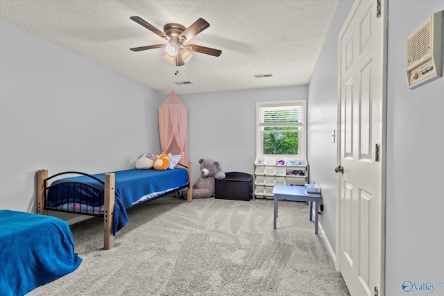 bedroom featuring ceiling fan, a textured ceiling, and light carpet