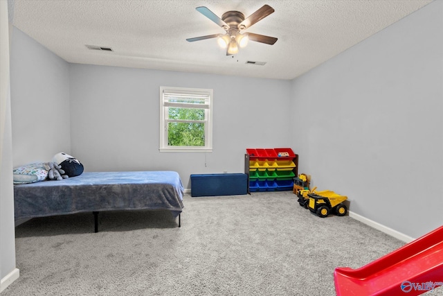 carpeted bedroom with a textured ceiling and ceiling fan