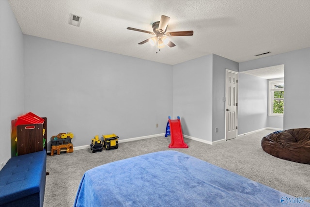 bedroom featuring a textured ceiling, carpet flooring, and ceiling fan