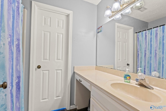 bathroom featuring a textured ceiling and vanity