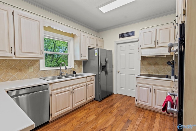 kitchen with light wood-type flooring, sink, backsplash, appliances with stainless steel finishes, and ornamental molding