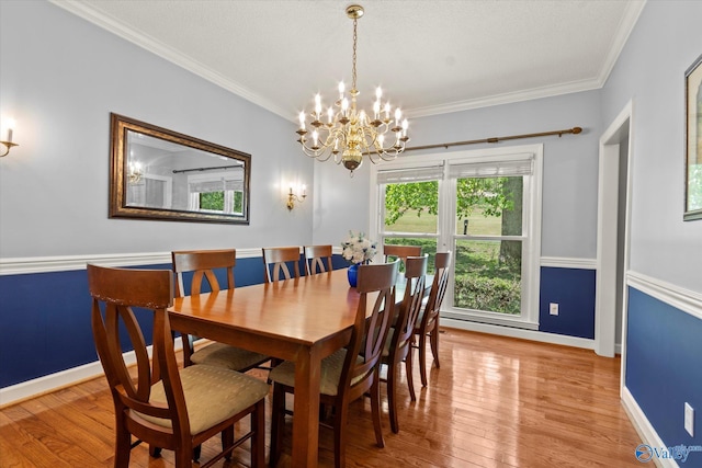 dining space featuring an inviting chandelier, light wood-type flooring, and crown molding