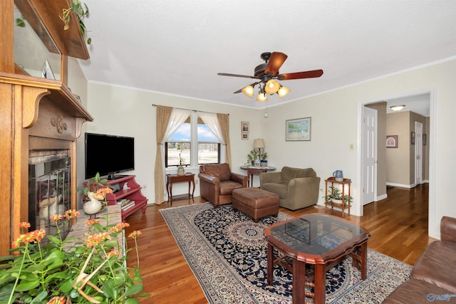 16904 Linton Rd, Athens, AL 35613 - living room featuring ceiling fan, wood finished floors, a glass covered fireplace, crown molding, and baseboards