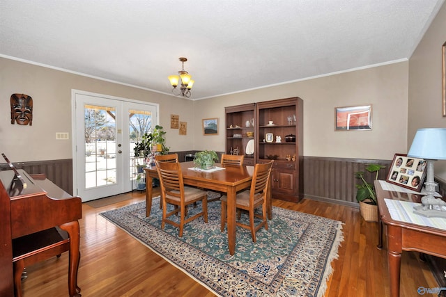 16904 Linton Rd, Athens, AL 35613 - dining room with a wainscoted wall, wood finished floors, a chandelier, french doors, and crown molding